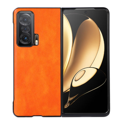 Orange litchi-textured phone case with black edge trim, triple-camera cutout and raised lip