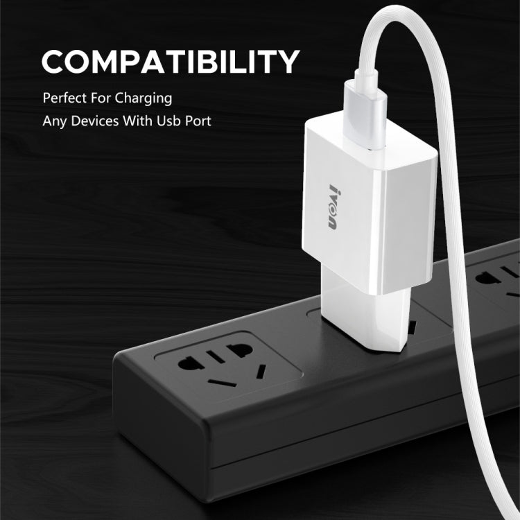 White dual-port travel USB charger plugged into an outlet with charging cable