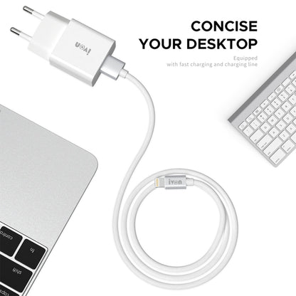 White travel charger with USB cable connected, placed near a laptop keyboard