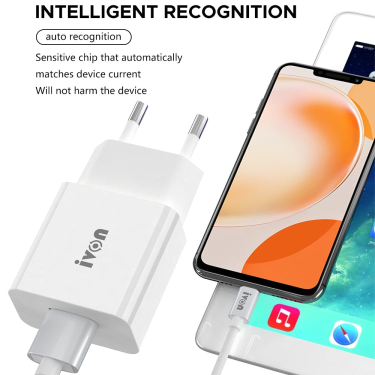 White dual-port travel charger beside a smartphone with charging cable