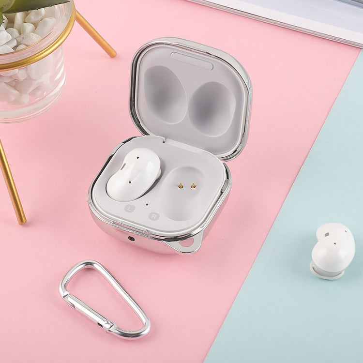 Silver earphone protective case open with white earbuds and metal keyring
