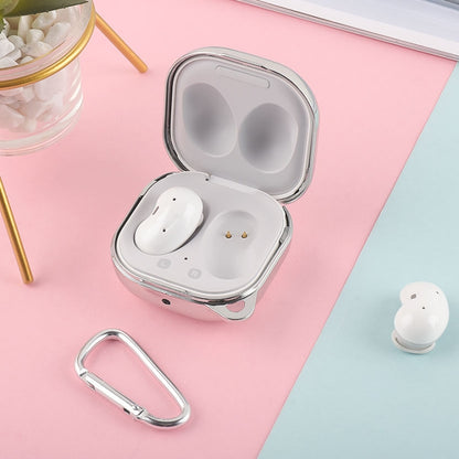 Silver earphone protective case open with white earbuds and metal keyring