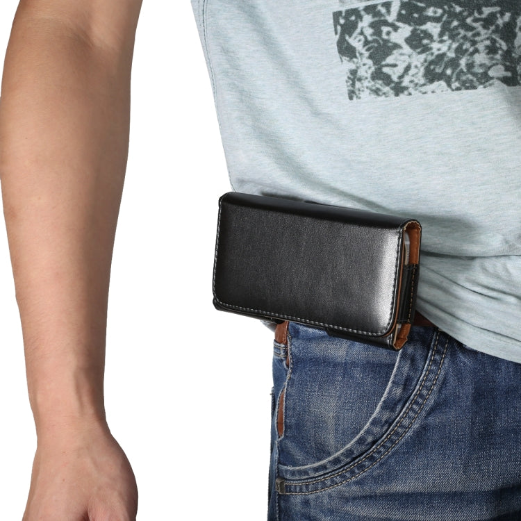 Phone case worn on waist with belt strap over blue jeans, front flap visible