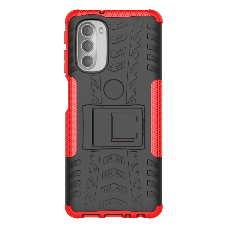 Red and black rugged phone case with tire tread texture, holder cutout, and camera openings