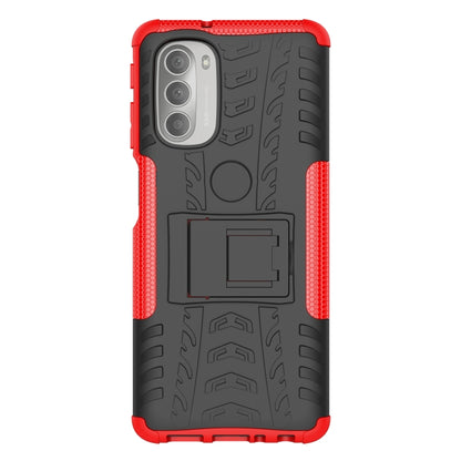 Red and black rugged phone case with tire tread texture, holder cutout, and camera openings