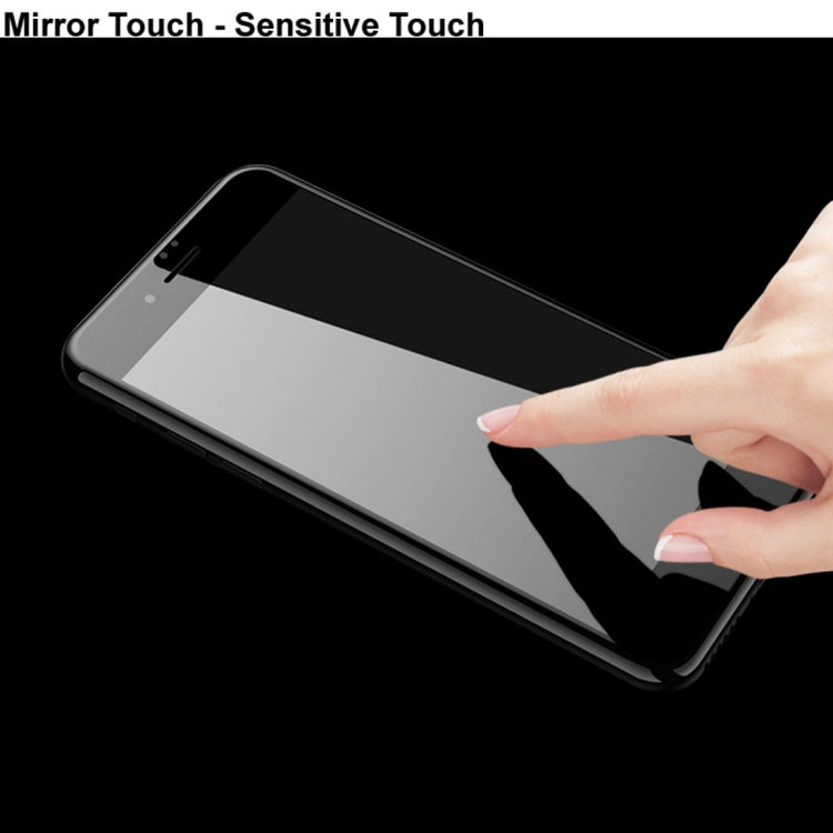 Hand applying tempered glass screen protector; thin clear sheet on smartphone front.