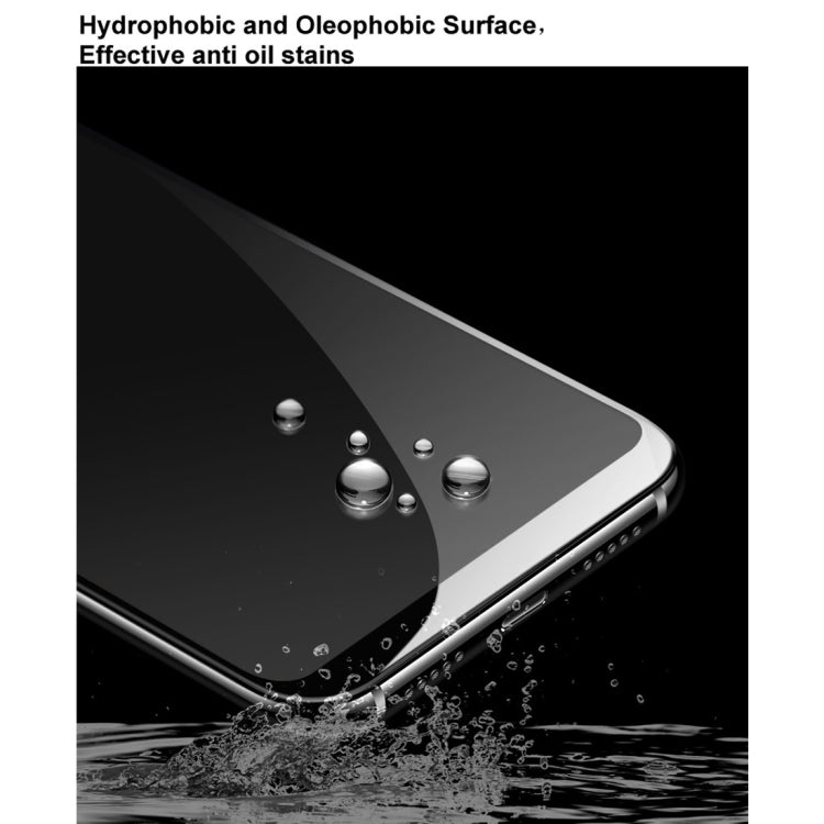 Tempered glass screen protector with water droplets on dark phone display surface.