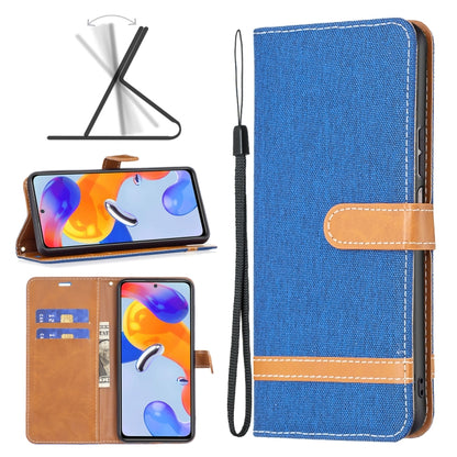 Blue denim-texture phone wallet case with tan leather strap and wrist lanyard.
