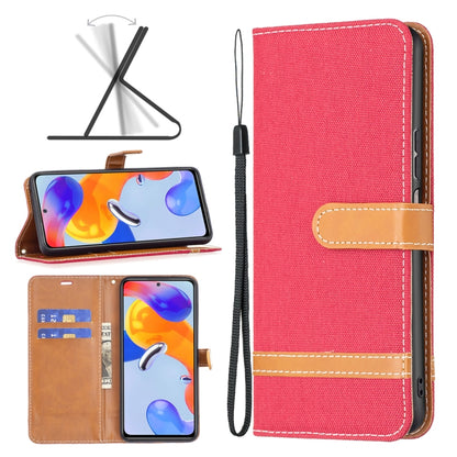 Red denim-texture phone wallet case with tan leather strap, stitching, and wrist lanyard.