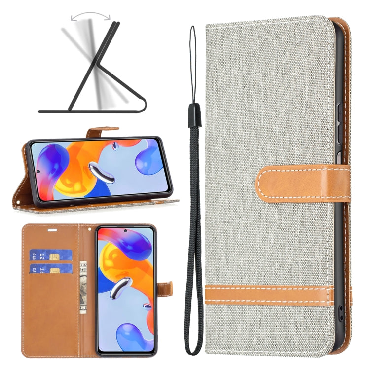 Light gray denim-texture phone wallet case with tan strap, stitching, and wrist lanyard.