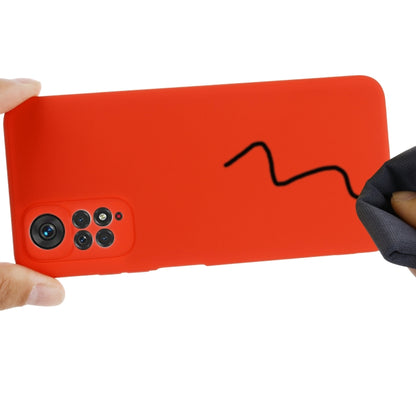 Red liquid silicone phone case held in hand, side profile with cutouts