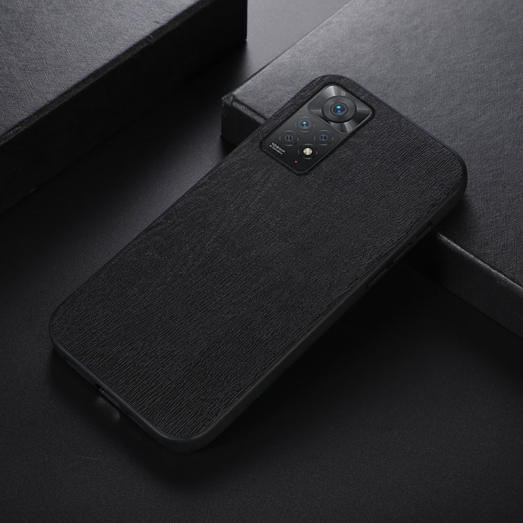 Black wood-grain PU phone case shown at an angle, with camera lens cutout