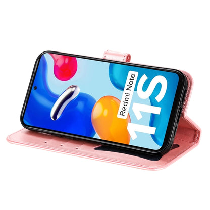 Rose gold leather flip phone case with embossed floral pattern, holding phone in portrait stand