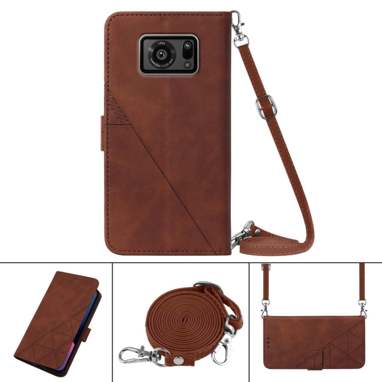 Brown leather flip phone case with embossed pattern and crossbody wrist strap.
