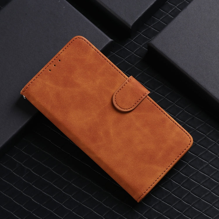 Brown leather magnetic flip phone case with snap strap and stitched front panel.