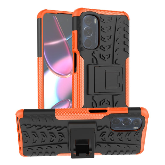 Tire-texture phone case with built-in holder, orange and black, for rear camera cutouts.