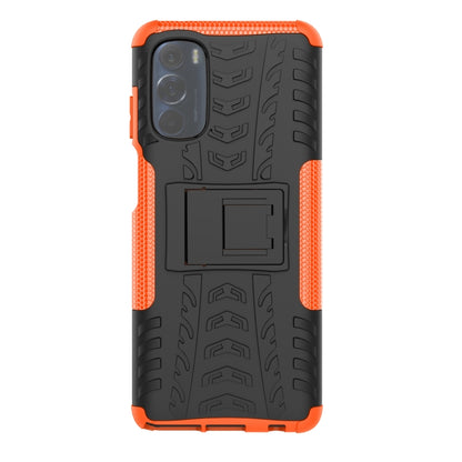 Tire-texture phone case with holder, orange accents and black back, camera opening visible.