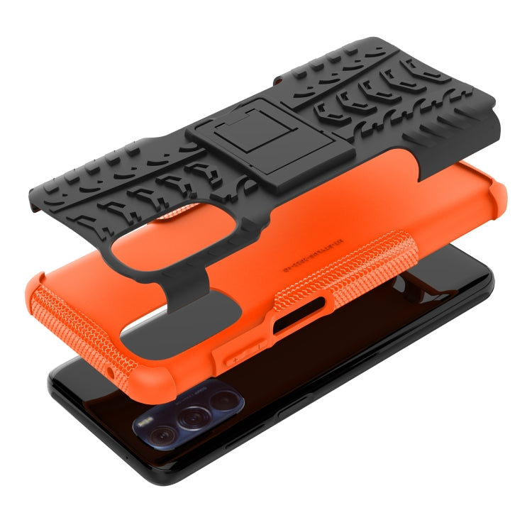Tire-texture phone case with holder stand, orange base with black textured top and cutouts.
