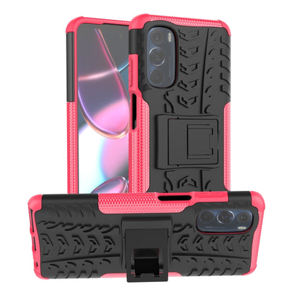 Tire-texture phone case with holder, red-pink and black, showing front and back cameras.