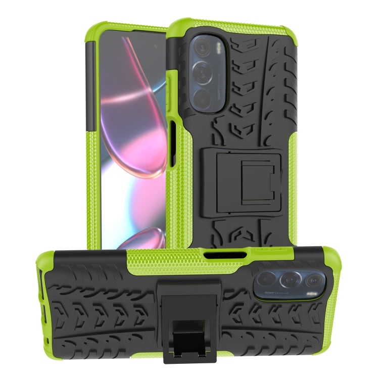 Tire-texture phone case with built-in holder, neon green and black, camera cutouts visible.