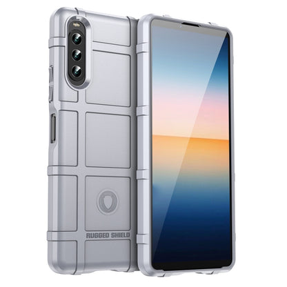 Light gray shockproof TPU phone case with rugged shield texture and camera cutouts