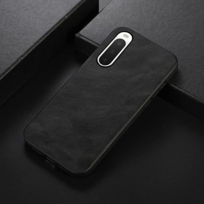 Black cowhide-textured PU phone case, angled view with camera cutout and ports