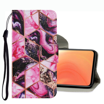 Pink geometric collage leather phone case with raised flap and wrist strap.