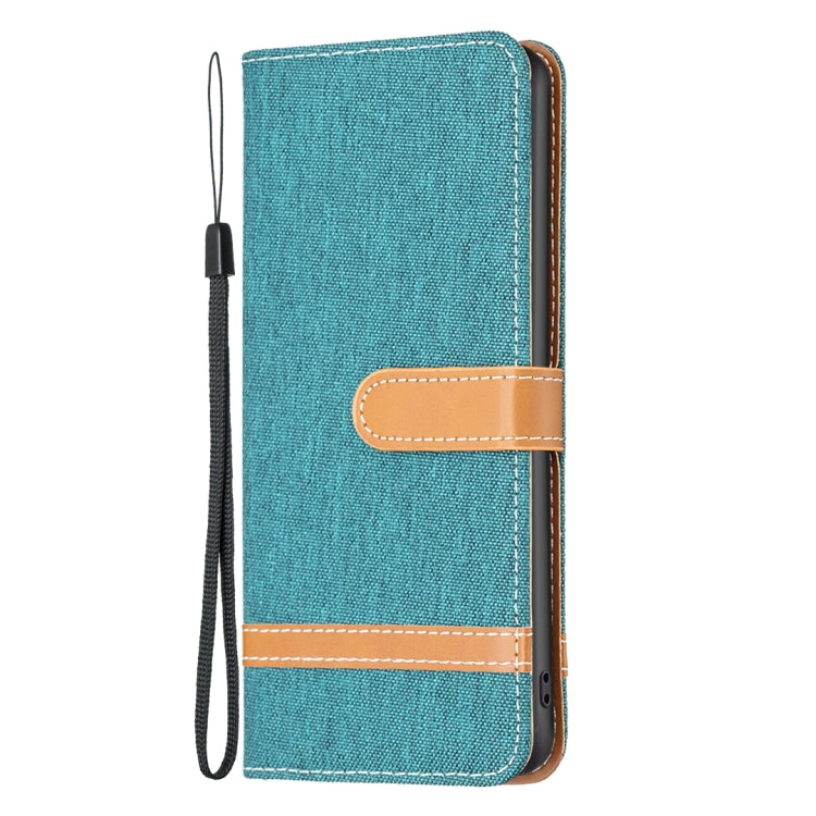 Teal denim-texture leather flip phone case with tan tab and attached wrist strap