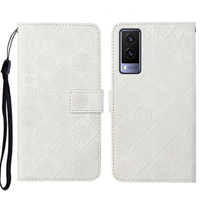 White embossed leather folio phone case with wrist strap and card pocket, visible rear cameras.