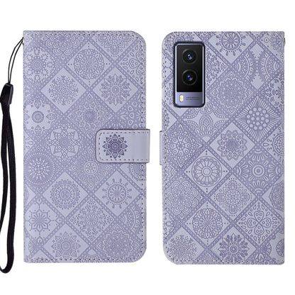Purple embossed leather folio phone case with wrist strap, card pocket, and rear camera openings.