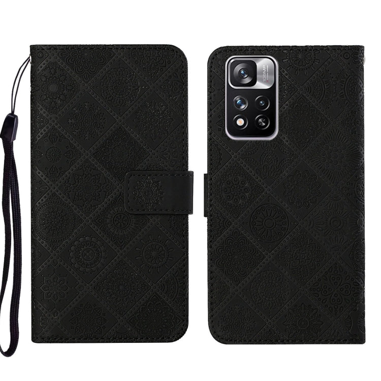 Black embossed leather phone case wallet with flip cover and wrist strap, rear camera view.