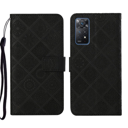 Black embossed leather phone case wallet with flip cover and wrist strap.