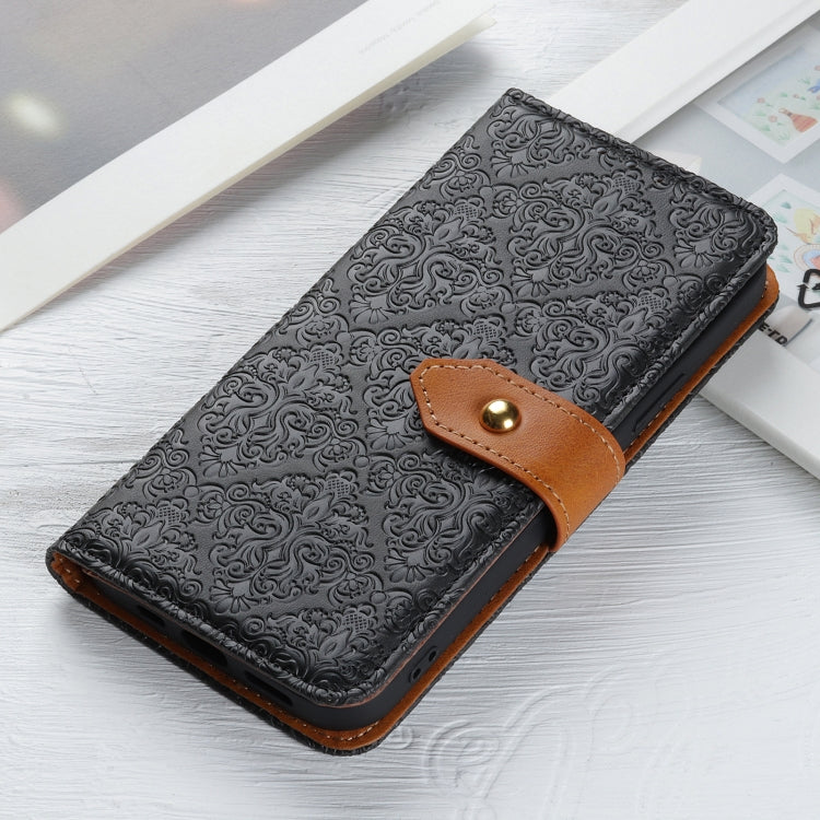Embossed black leather phone wallet case with tan snap strap on tabletop