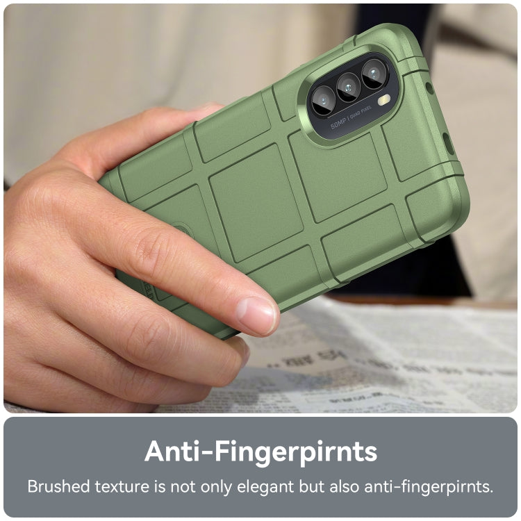 Green rugged TPU phone case in hand with camera cutout and button ports