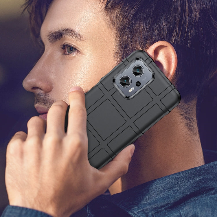 Black rugged shockproof TPU phone case held to ear with camera cutout
