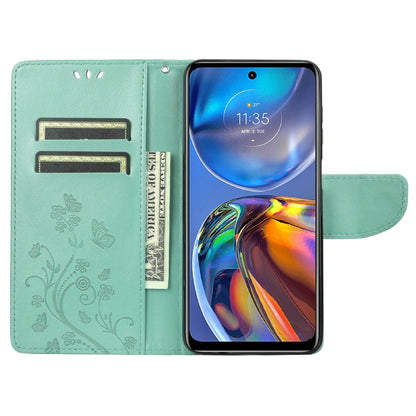Green leather flip phone case with butterfly-flower pattern, card slots, and viewing stand.