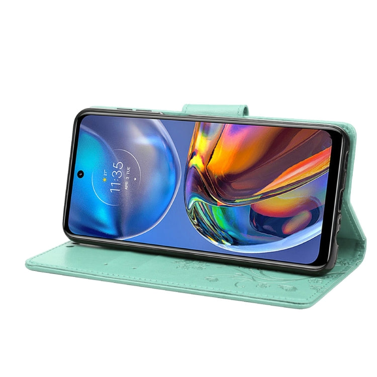 Green leather wallet flip phone case with butterfly-flower pattern and horizontal stand.