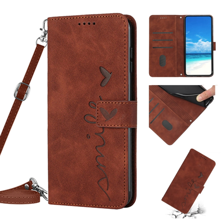 Brown leather phone case with heart pattern, wallet style, wrist lanyard.
