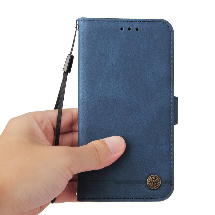 Blue leather wallet phone case held in hand with wrist strap and metal button.