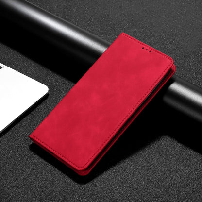 Red leather phone flip case with stitched edges, laid on black textured surface