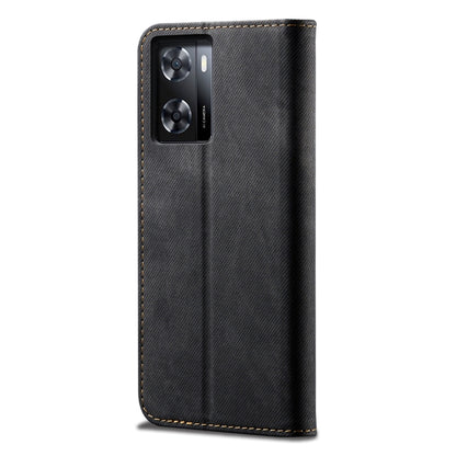 Black denim-textured flip phone case with camera cutout and gold-edged stitching.