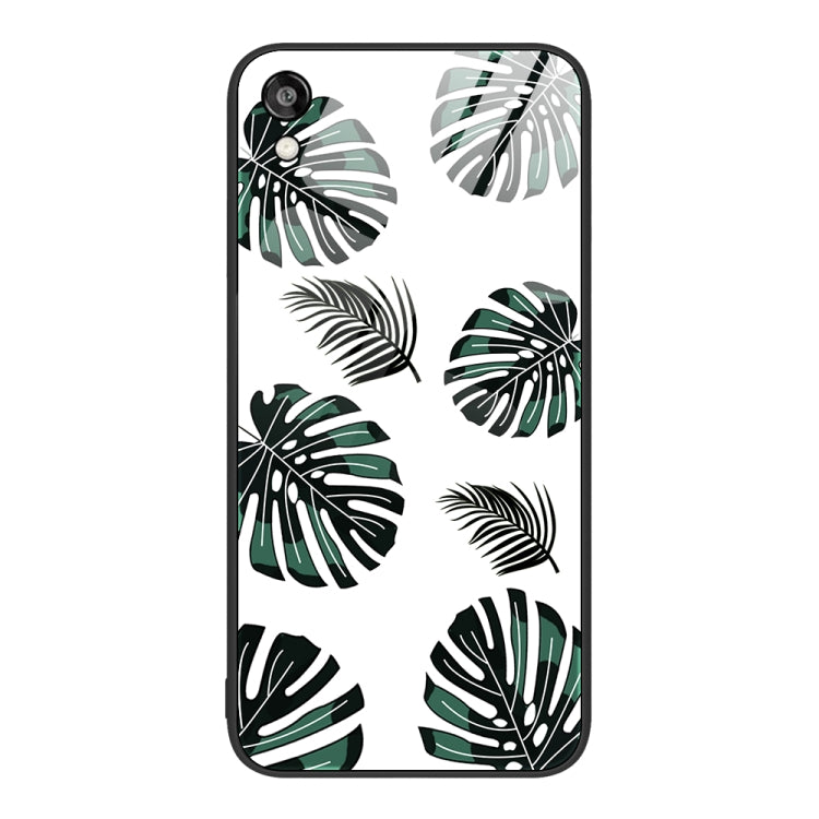 Glass phone case with green and black leaf pattern on a light background.