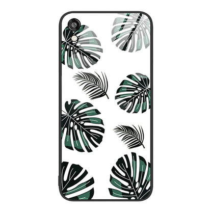 Glass phone case with green and black leaf pattern on a light background.