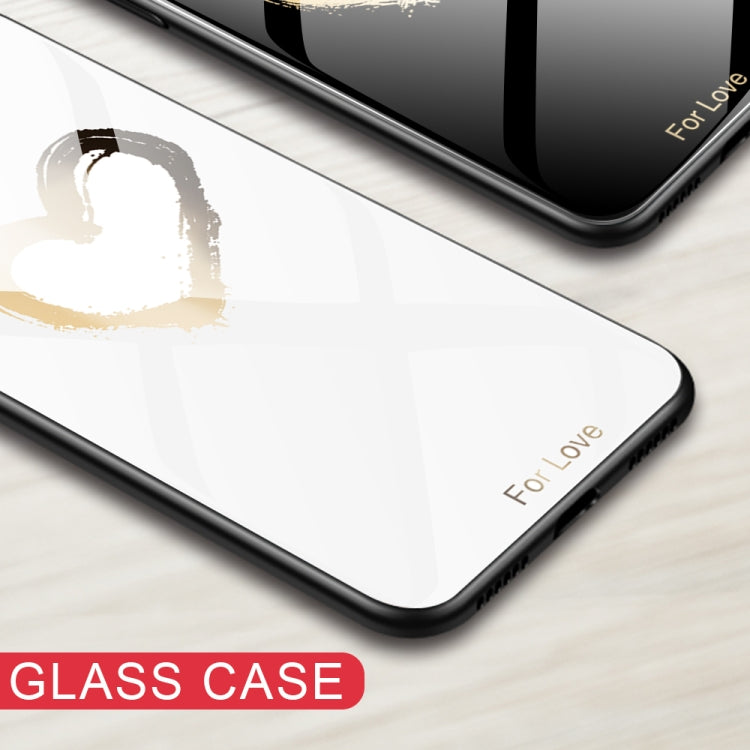 Glass phone case corner in white with a black frame and gold heart-style paint.