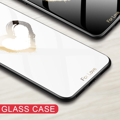 Glass phone case corner in white with a black frame and gold heart-style paint.