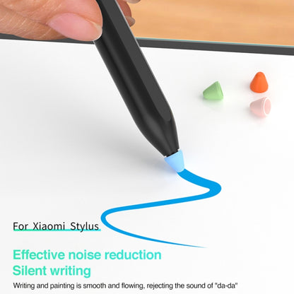 Hand inserting silicone nib cap on stylus tip, blue cap shown