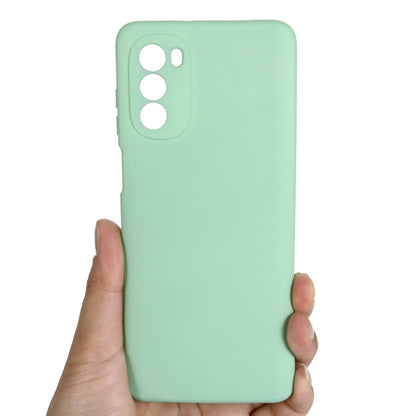 Mint green silicone phone case held in hand, with camera cutouts