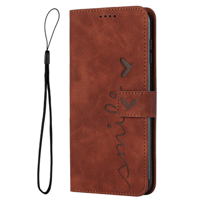 Brown leather flip phone case with heart pattern and attached wrist strap