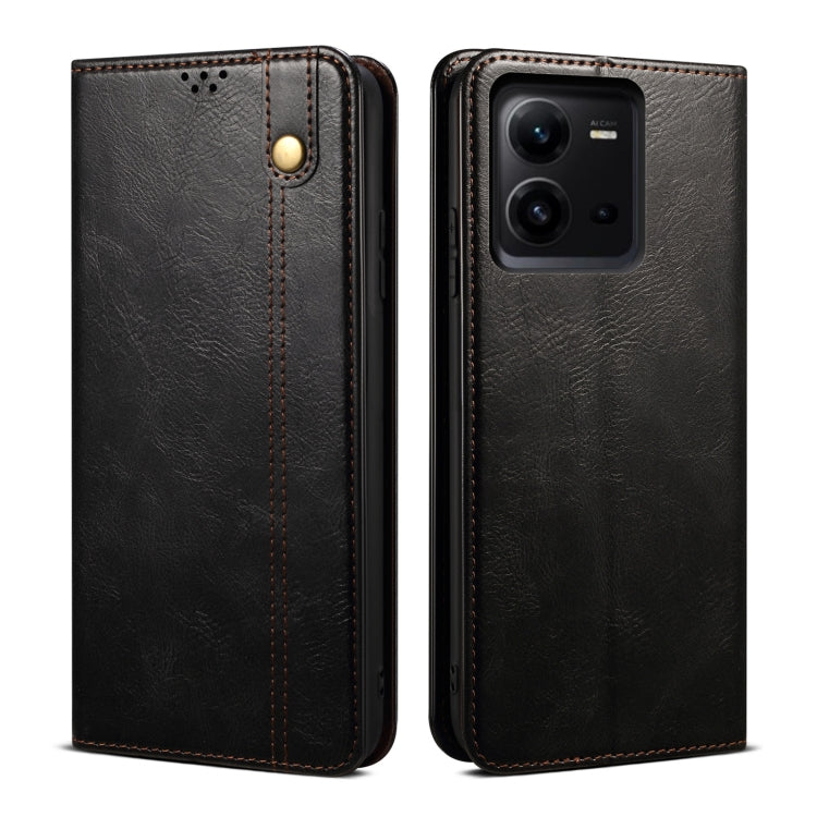 Black oil-wax leather phone case with embossed finish, gold-tone snap button, and camera opening