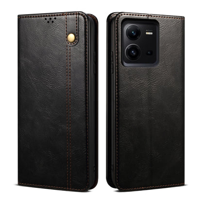 Black oil-wax leather phone case with embossed finish, gold-tone snap button, and camera opening
